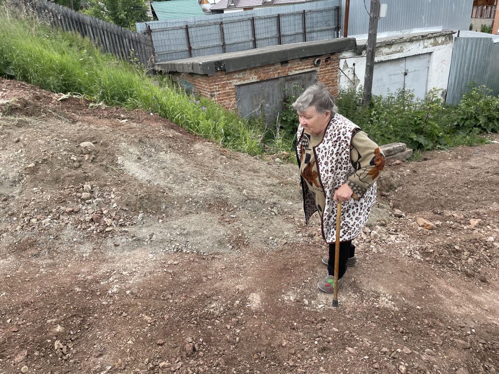 Лариса Лебедева просит, чтобы дорогу поскорее разровняли. Фото: Анна Куприянова, "Глобус" Лариса Лебедева просит, чтобы дорогу поскорее разровняли. Фото: Анна Куприянова, "Глобус"