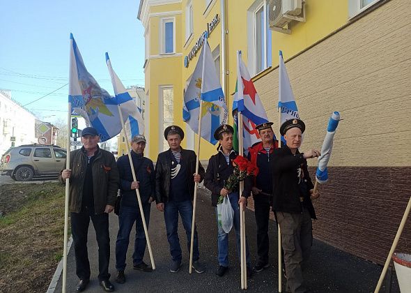 9 мая. Прошлогодние банеры на столбах, ветераны флота с гвоздиками, флаги на частных домах